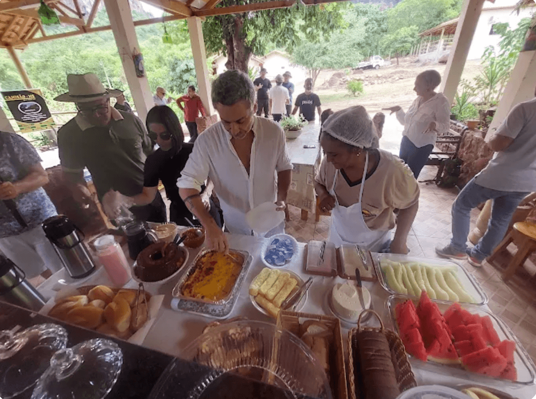 Huéspedes sirviéndose el desayuno con frutas, tortas y pan casero