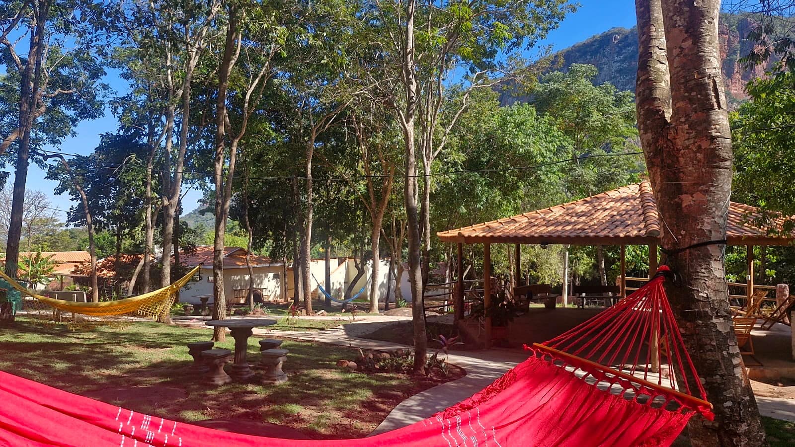 Contemplation area with colorful hammocks, a lawn path, and sandstone cliffs.