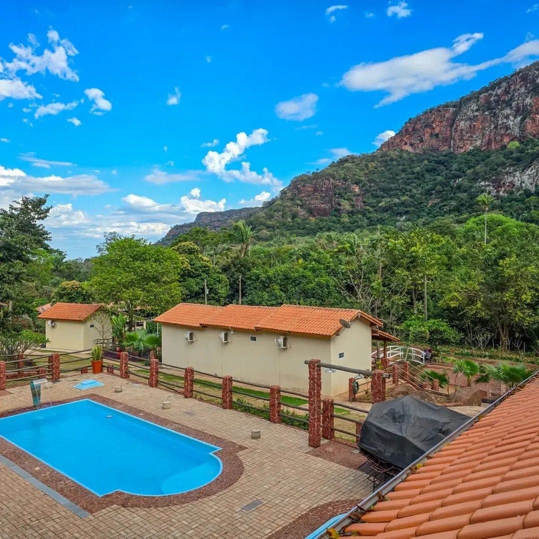 Pousada pool with blue water and Morro do Paxixi in the background.