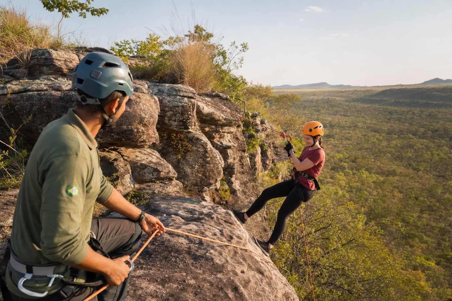 Visitor rappelling with helmet and safety gear under a guide at Morro do Paxixi.